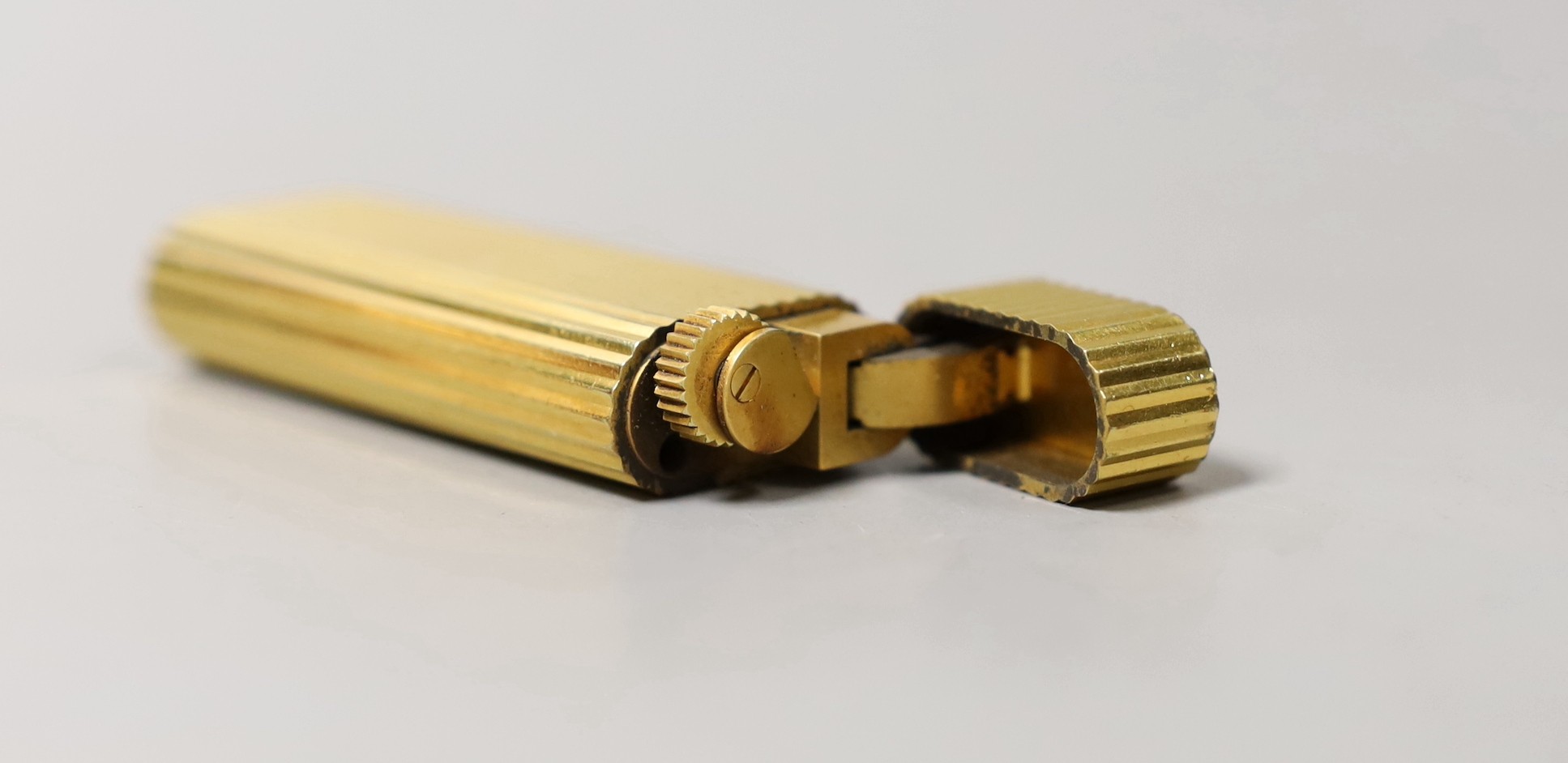 A Must de Cartier gold plated lighter, cased, 7cms long